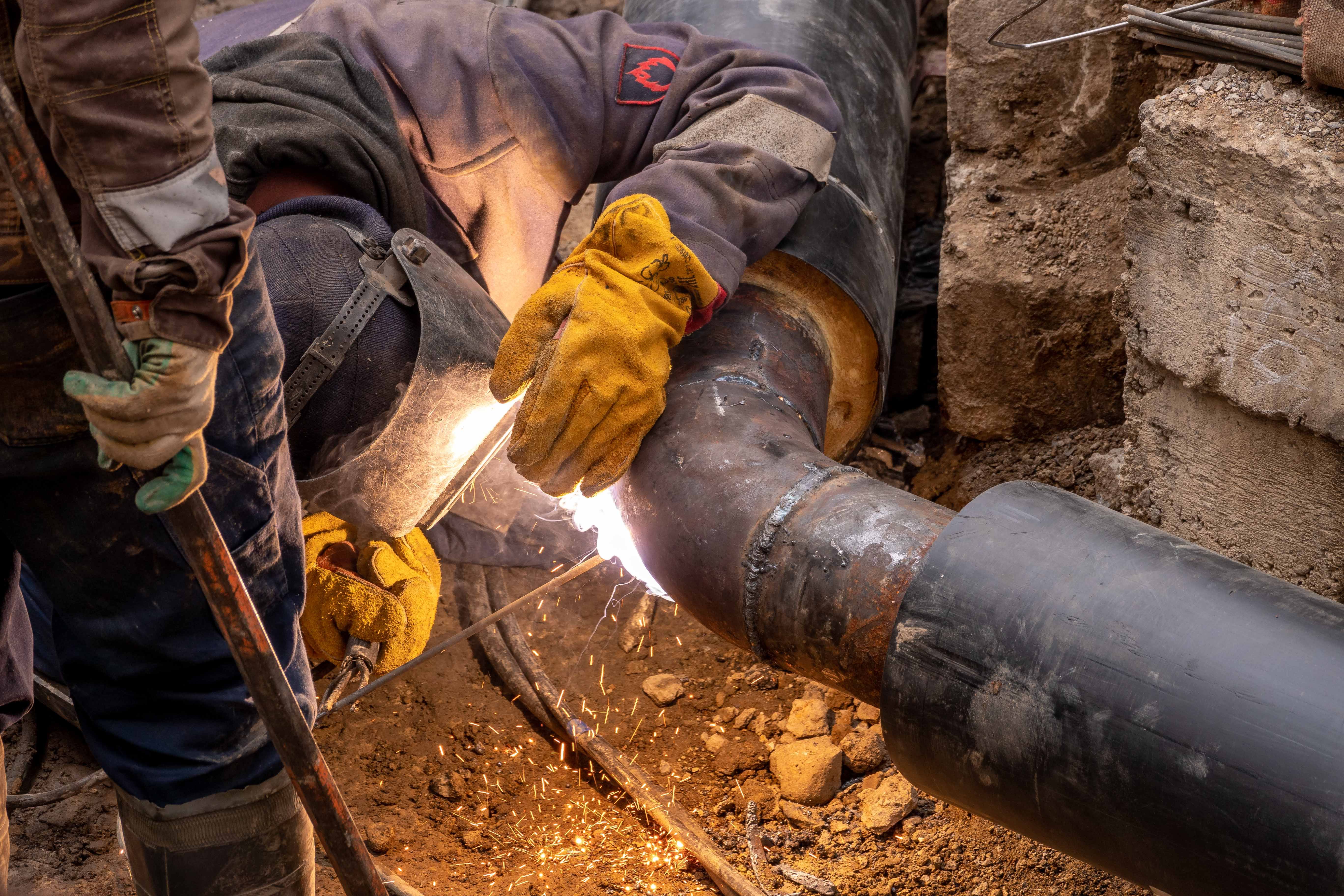 Plumber working on pipework under a sink